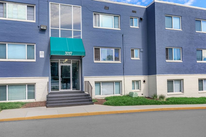 a blue building with a green awning and a street in front of it at Regency Court, Suitland, MD - Photo Gallery 1