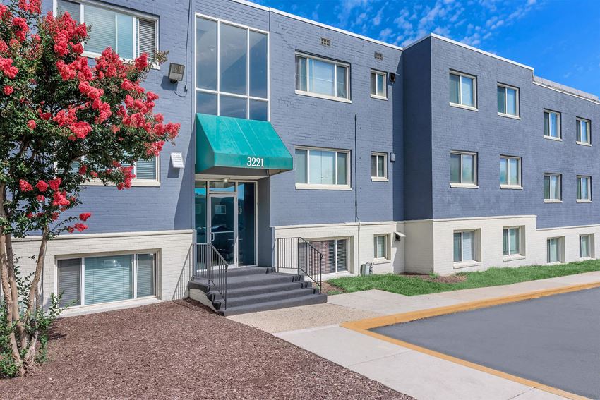 a blue building with a green awning and a red tree in front of it a blue building with a green awning and a red tree in front of it at Regency Court, Suitland, 20746 - Photo Gallery