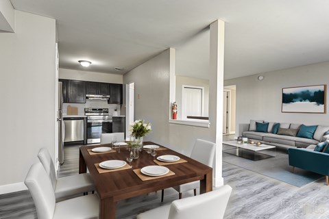 A modern dining room with a wooden table set for two.
