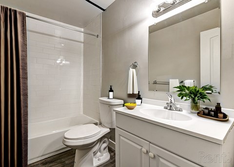 A white bathroom with a toilet, sink, and mirror.