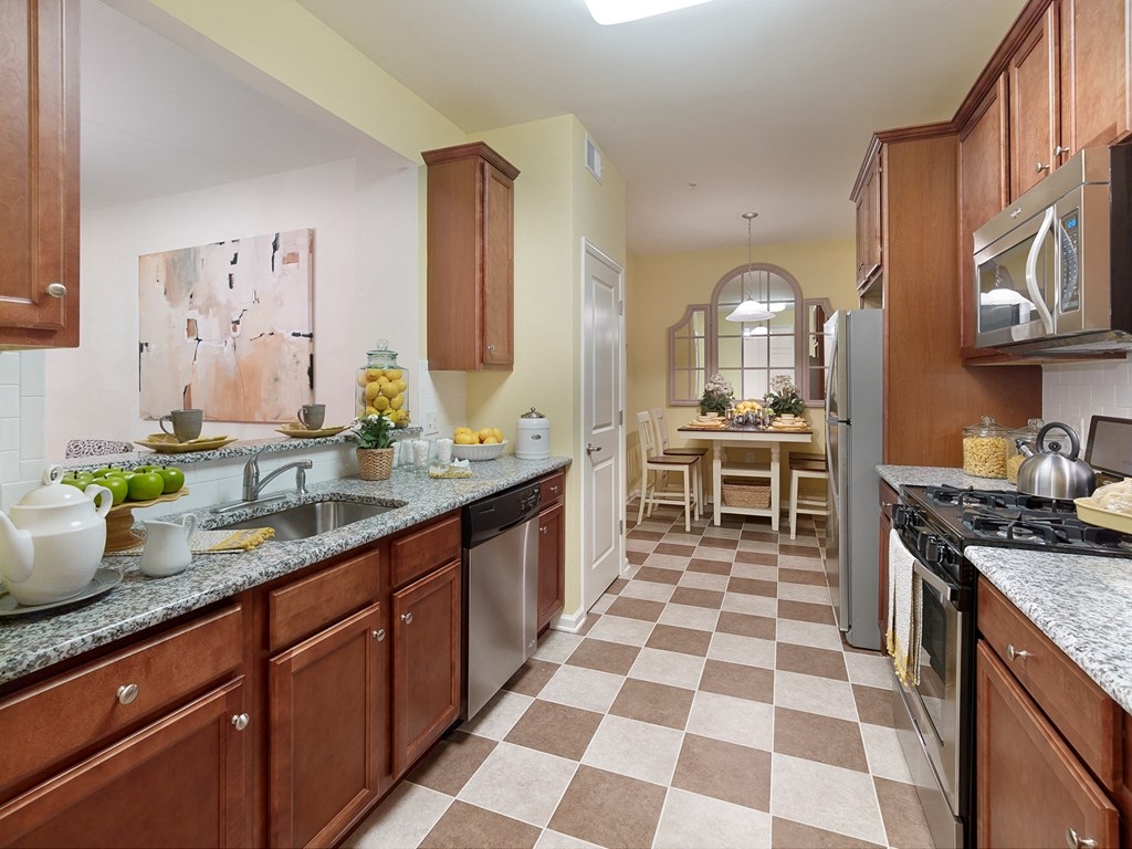 a kitchen with granite counter tops and wooden cabinets