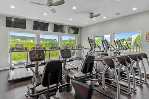 Resident gym with modern exercise machines and TVs
