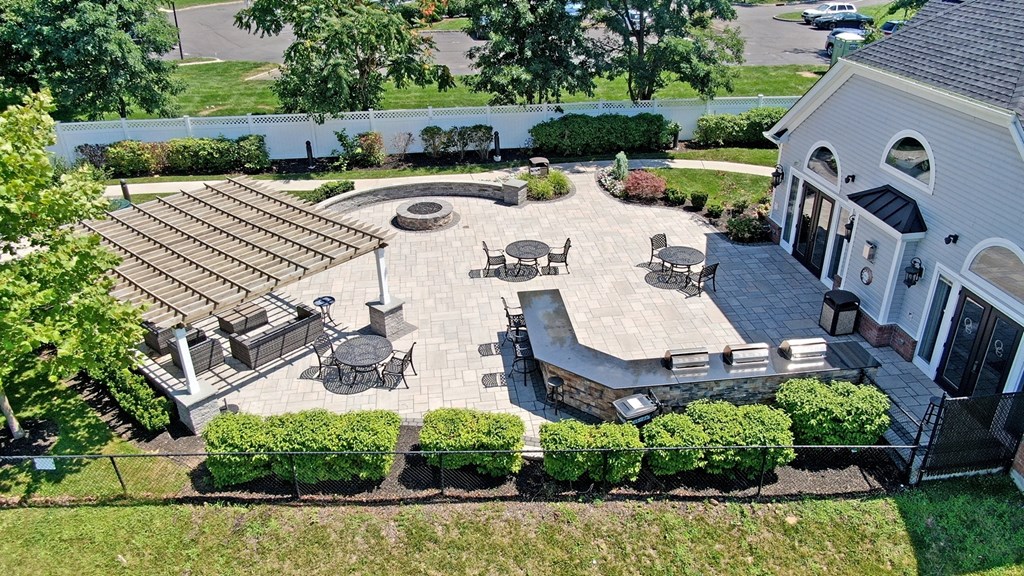 A patio area with a table and chairs is surrounded by a well-manicured garden.