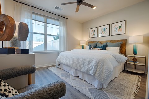 A bedroom with a large bed and a ceiling fan.
