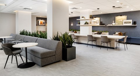 A modern living room with a grey couch and a white table.
