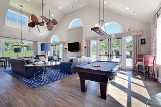 a large living room with a pool table and a tv