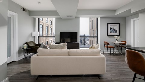 A living room with a white couch and a television.
