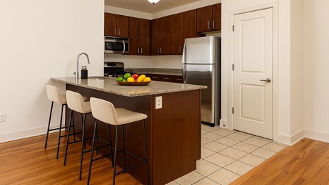 A kitchen with a refrigerator, microwave, and oven.