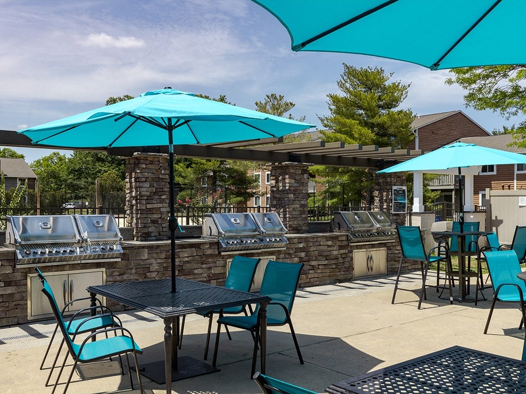 a patio with blue umbrellas and tables with chairs