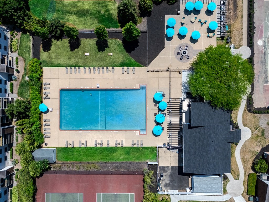 a birds eye view of the pool of a building with umbrellas