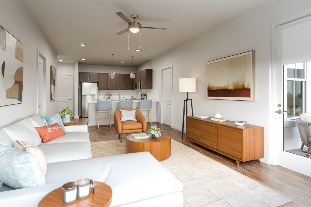 A living room with a white couch and a brown side table.