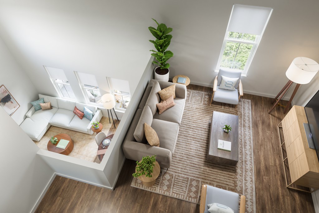 A living room with a couch, a chair, a coffee table, and a potted plant.