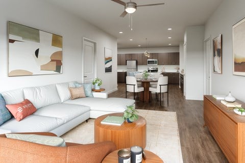 A modern living room with a white couch and a wooden coffee table.