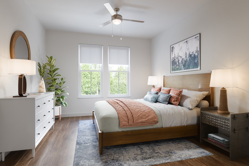 A bedroom with a bed, dresser, and ceiling fan.