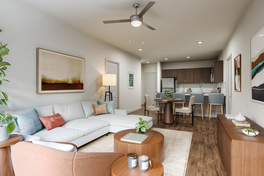 A living room with a white couch, a coffee table, and a dining table with chairs.