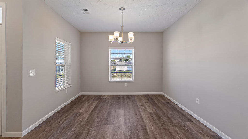 an empty living room with wood floors and a window