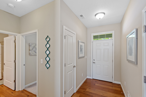 a living room with white doors and a hallway with a door to a closet