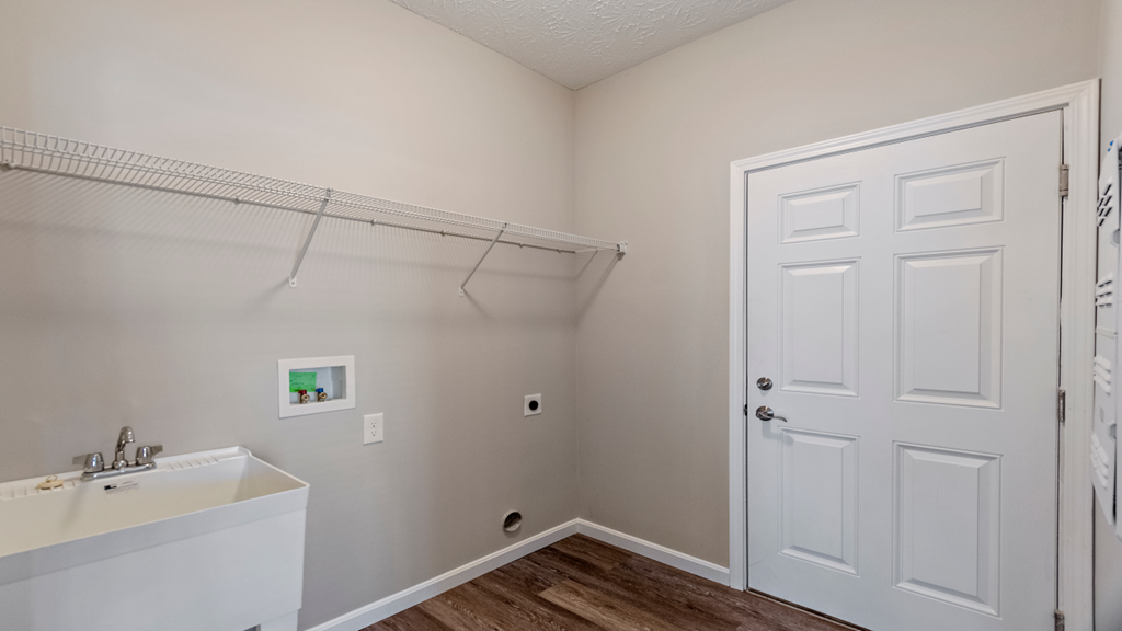 an empty bathroom with a white door and a white sink