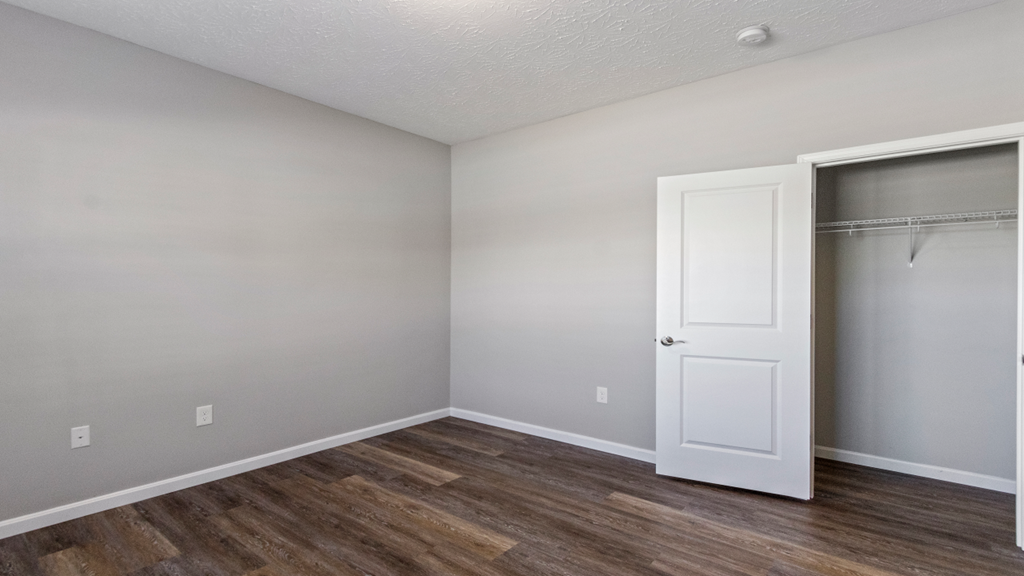 an empty bedroom with a closet and a door to the bathroom
