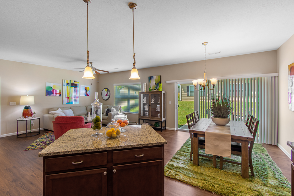 a living room and dining room with a table and chairs