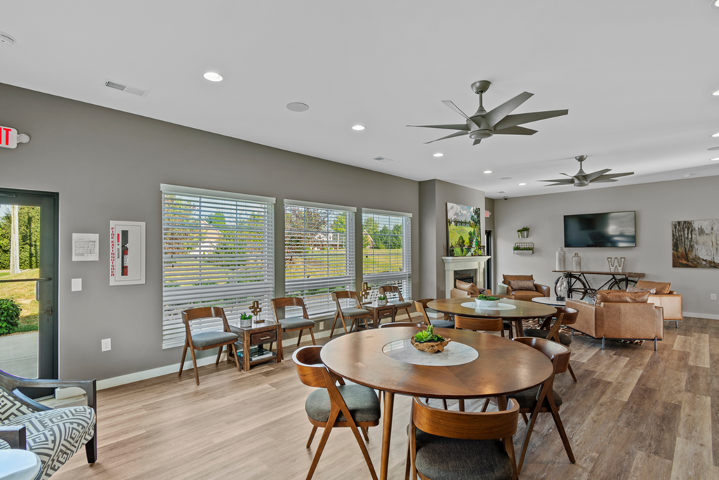 A dining room with a round table and chairs.