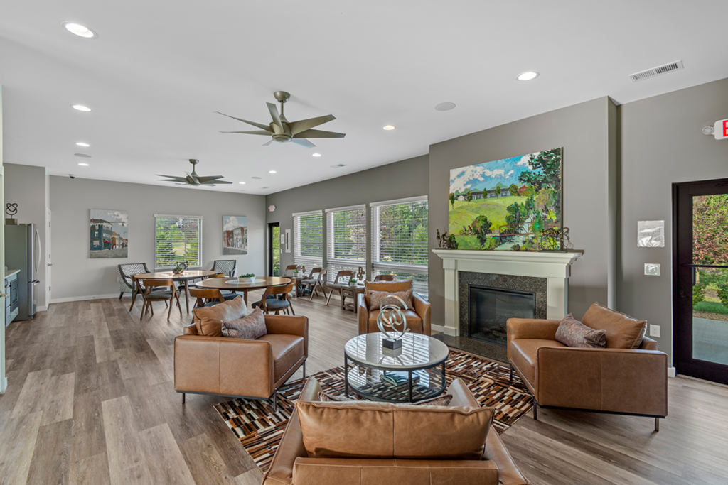 A living room with a fireplace and a painting on the wall.