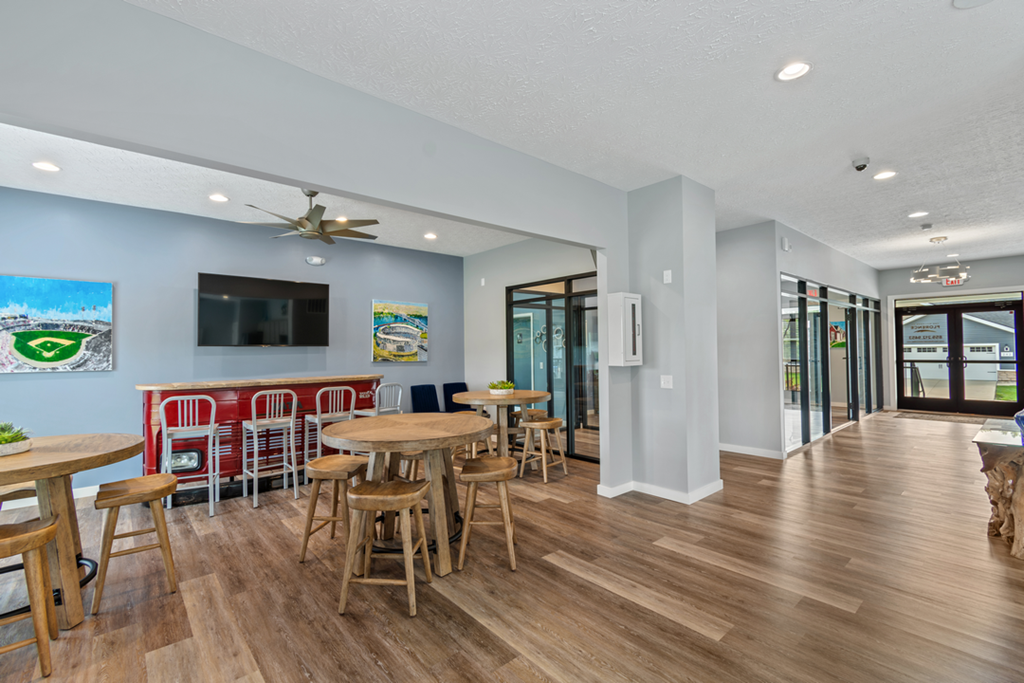 a dining area with tables and chairs and a tv on the wall