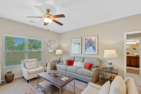 a living room with a couch and a ceiling fan