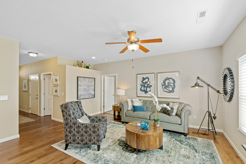 a living room with furniture and a ceiling fan