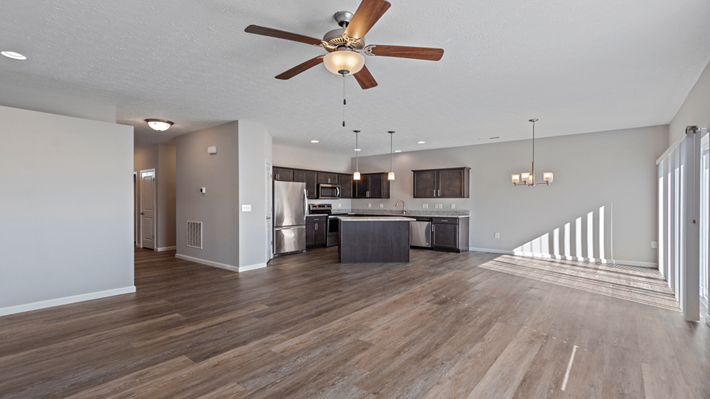 an open living room and kitchen with a ceiling fan