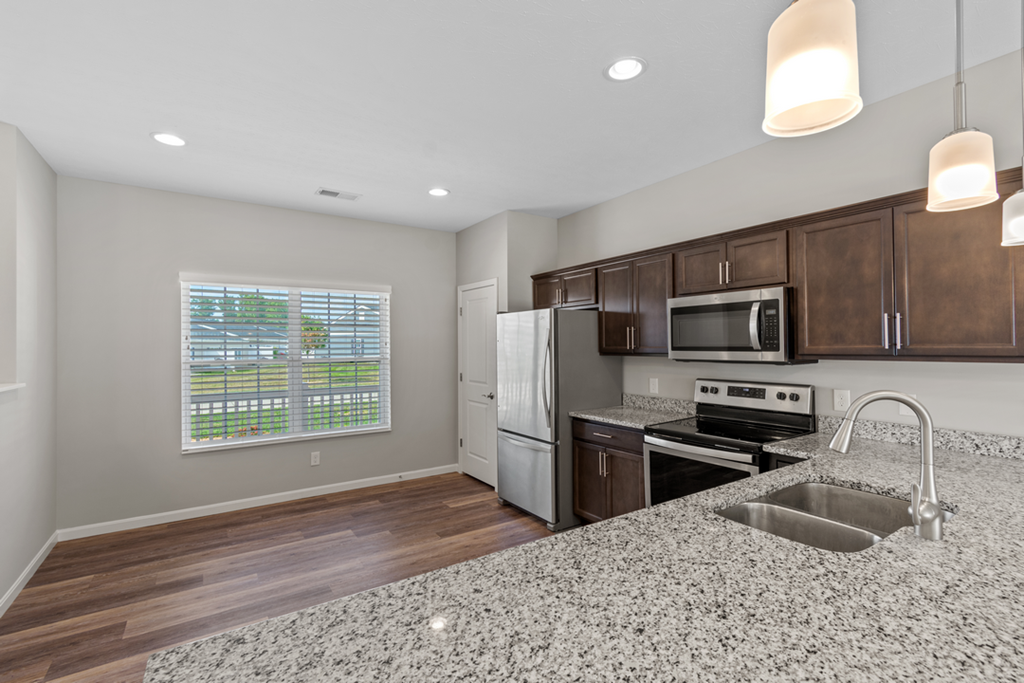 an empty kitchen with a granite counter top and a sink