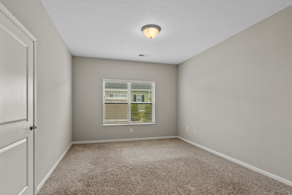 an empty room with carpet and a window