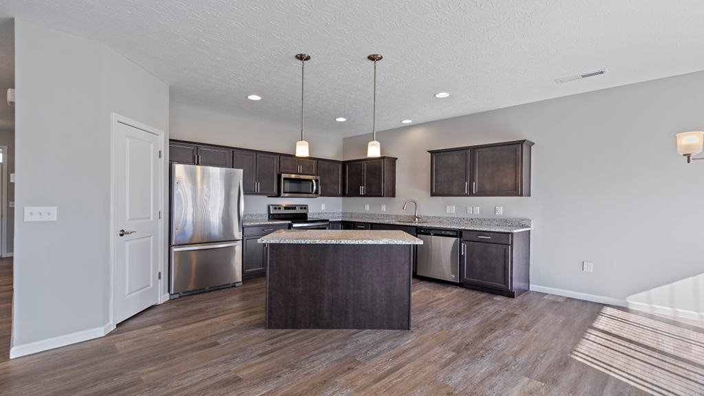 a kitchen with stainless steel appliances and a marble counter top