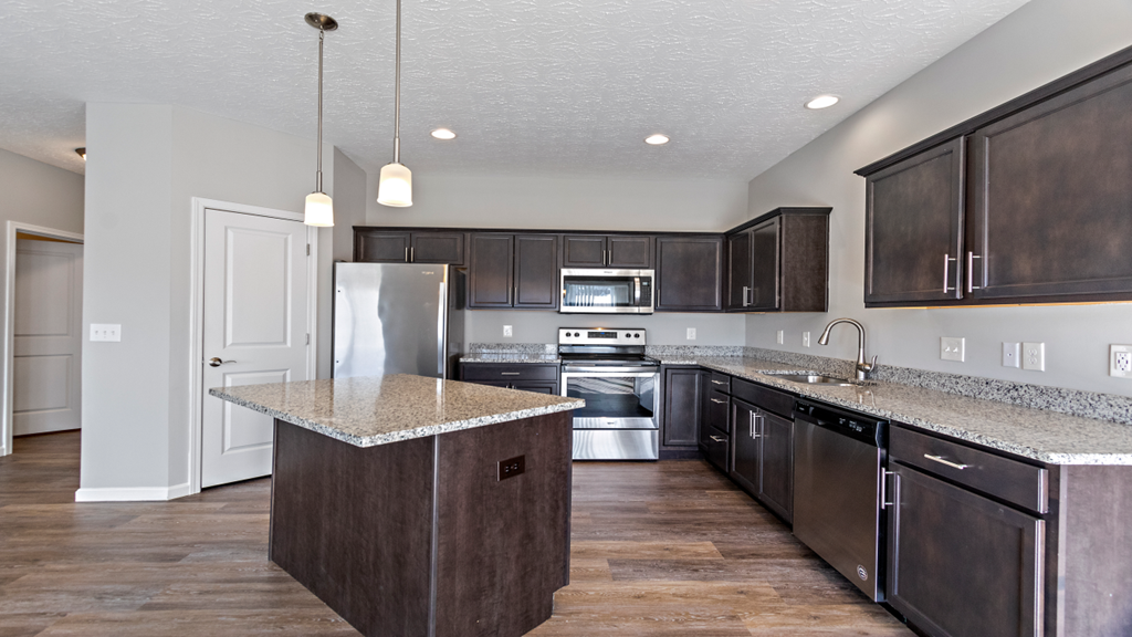 a kitchen with a granite counter top and wooden cabinets