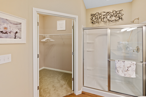 a closet in a bathroom with a glass door