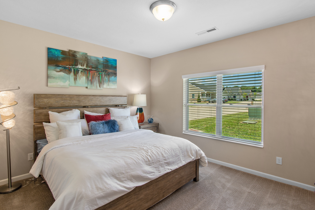a bedroom with a large bed and a window