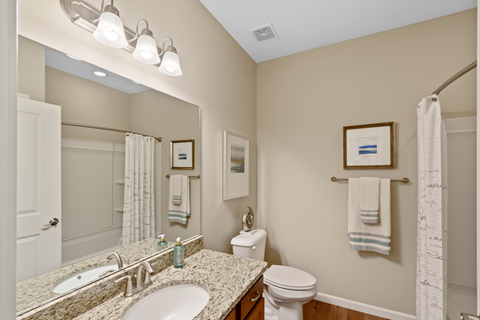 a bathroom with two sinks and a toilet and a shower