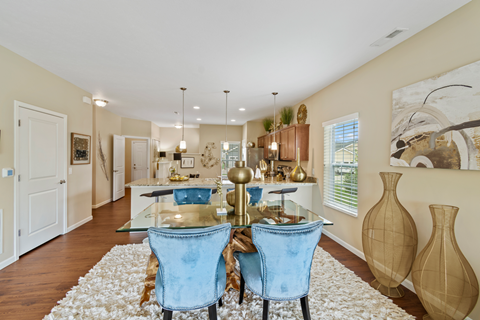 a dining room and kitchen with a glass table and chairs