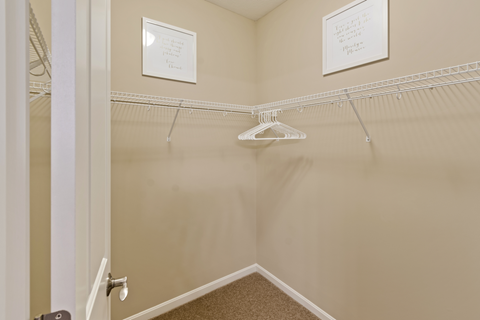 an empty closet in a home with a hanging rack on the wall