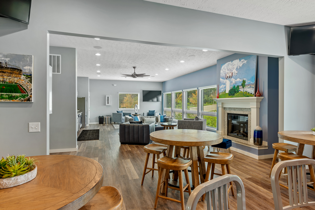 a living room with tables and chairs and a fireplace