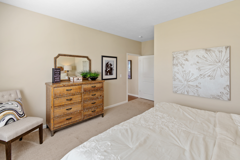 a bedroom with a white bed and a dresser