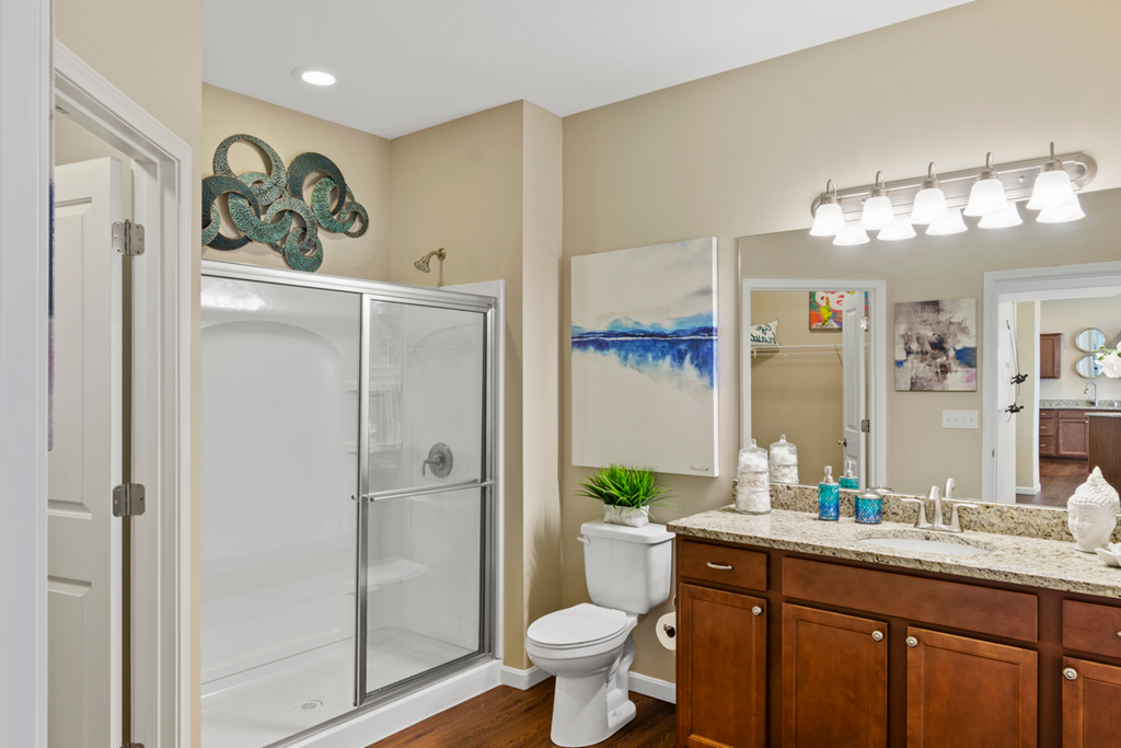 a bathroom with a shower toilet and sink and a mirror