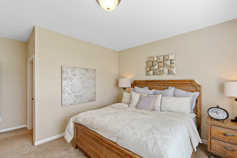 a bedroom with a bed and two lamps and a clock