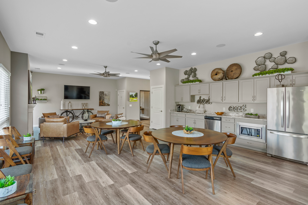 a living room with a dining room and a kitchen with a table and chairs