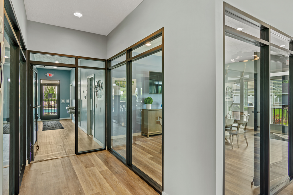a hallway with glass sliding doors and a conference room