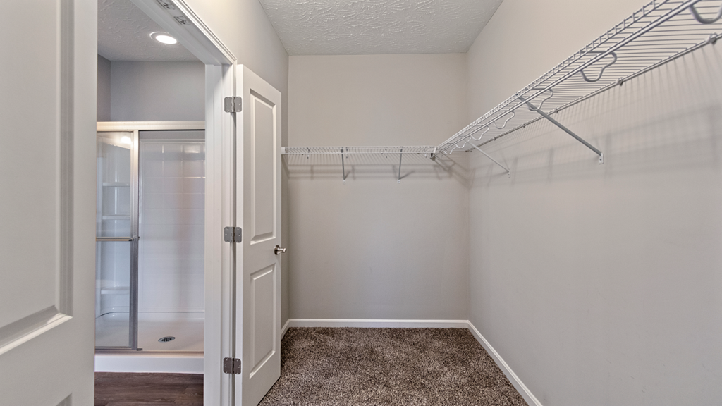 an empty bathroom with a closet and a shower