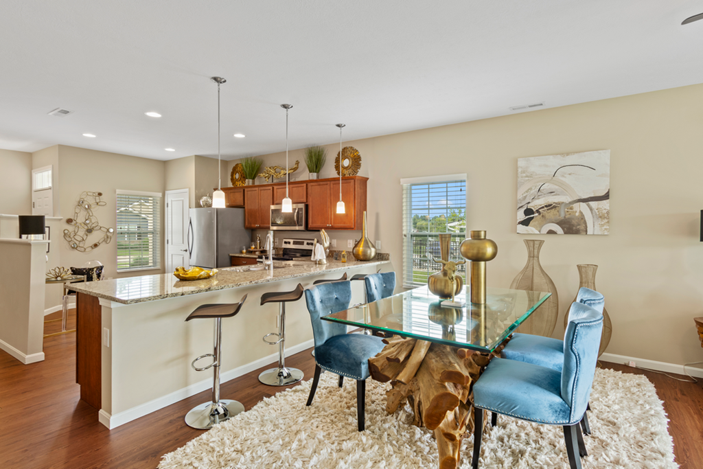 an open kitchen and dining area with a glass table and chairs