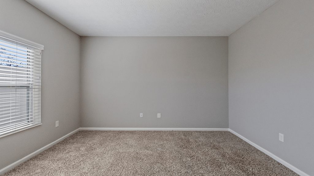 an empty room with carpet and a window