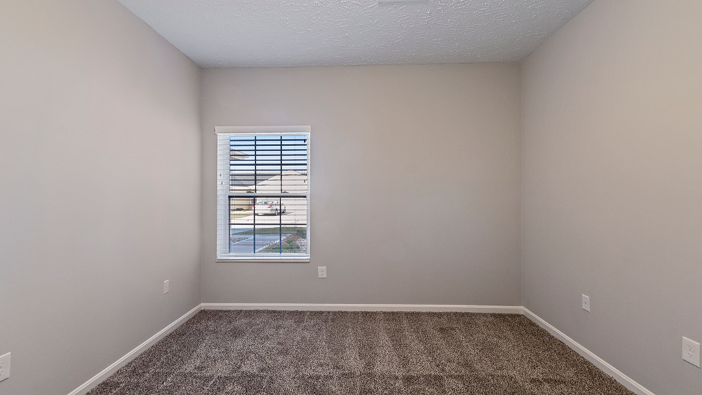 an empty room with carpet and a window