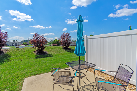 a patio with a table and chairs and an umbrella